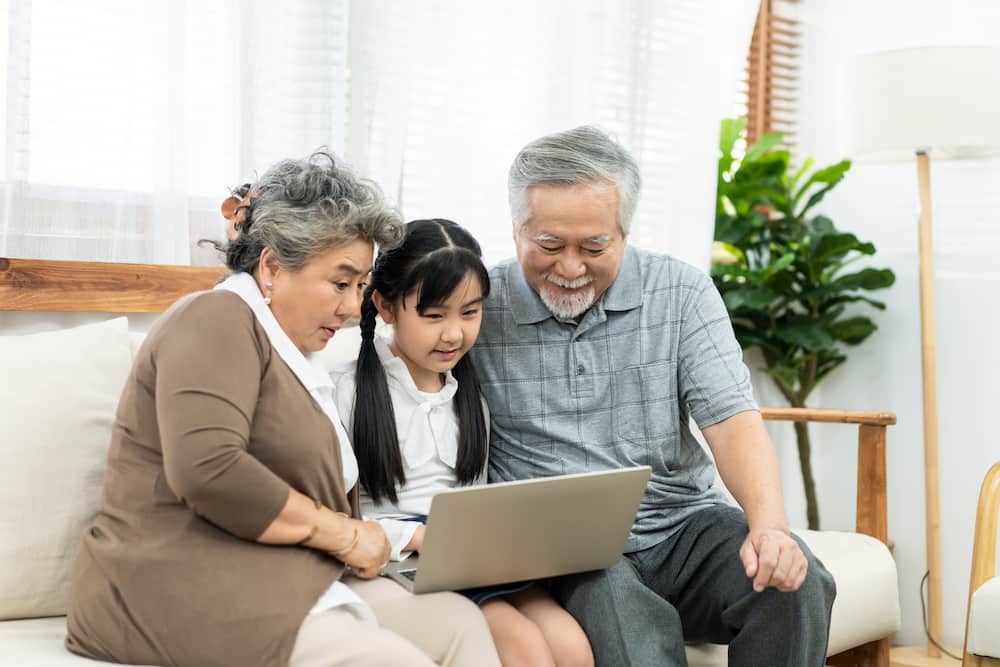 kids interacting with grandparents learning on device